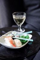 Sushi dans un bol avec des baguettes et du vin