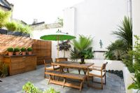 Jardin patio contemporain avec mobilier en bois et parasol vert