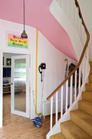 Couloir avec murs roses et escalier incurvé