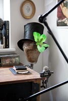 Chapeau haut de forme avec ornement papillon sur coin de bureau en bois