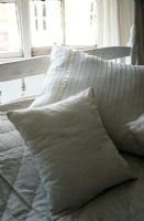 Coussins blancs et dorés sur le lit