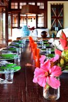 Fleurs tropicales sur une longue table à manger en bois pour le repas
