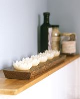 Rangée de bougies en forme de lotus sur un plateau en bois
