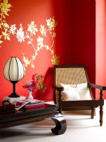 Meubles de style oriental en bois foncé contre le mur rouge