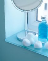 Miroir et accessoires sur étagère de salle de bain