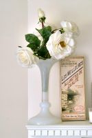 Vase de roses blanches sur le détail de la cheminée