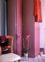 Paravent décoratif rose avec chaise et orchidée