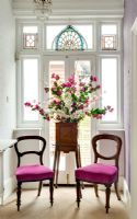 Stand de fleurs et chaises par vitrail