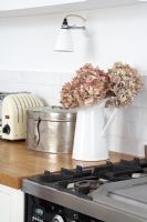 Cruche de fleurs séchées sur le plan de travail de la cuisine