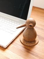 Oiseau en bois à côté d'un ordinateur portable