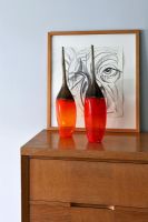 Vases rouges sur armoire en bois