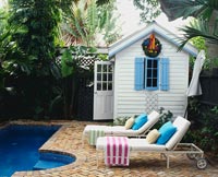 Chaises longues et pavillon d'été dans un jardin tropical