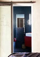 Vue d'une salle de bain compacte par une porte coulissante