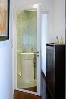 Hall contemporain avec salle de bain reflétée dans la porte