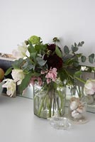 Arrangement d'eucalyptus et de tulipes dans un vase en verre