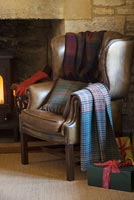 Fauteuil en cuir par cheminée en pierre des Cotswolds à Noël