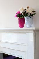 Pivoines roses dans des vases sur une cheminée en marbre