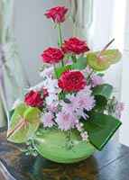 Roses, chrysanthèmes et lis d'Arum dans un vase vert