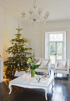 Salon blanc avec arbre de Noël et cadeaux