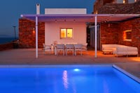 Villa grecque et piscine éclairées la nuit
