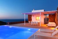 Villa grecque et piscine éclairées la nuit