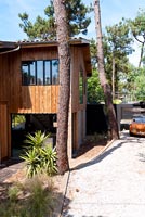 Maison contemporaine en bois entourée d'arbres
