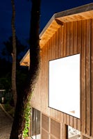 Maison contemporaine en bois éclairée la nuit