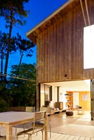 Maison contemporaine en bois éclairée la nuit
