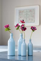 Fleurs d'anémone dans des bouteilles bleues