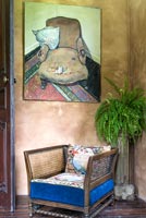 Peinture accrochée au-dessus d'une chaise vintage