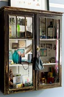 Ornements et accessoires vintage affichés dans une armoire en bois