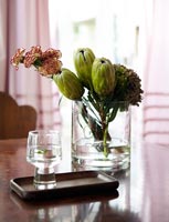 Oeillets et bourgeons de Protea dans un vase en verre