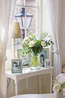 Table basse avec affichage de photos et de roses dans un vase