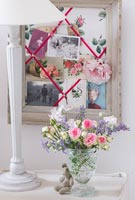 Roses et fleurs de menthe dans un vase et un tableau d'affichage
