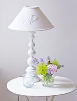 Lampe blanche et fleurs sur table vintage