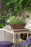 Plantes poussant dans un panier en osier sur une table de jardin