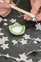 Création d'une décoration de Noël simple à l'aide de papier journal et de ficelle - ajout de colle à l'étoile