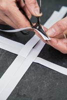 Utiliser des bandes de papier pour créer des décorations en forme d'étoile - couper une fine fente du coin de chaque bande