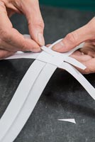 Utilisation de bandes de papier pour créer des décorations en forme d'étoile - bande de filetage sous la section pliée
