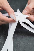 Utiliser des bandes de papier pour créer des décorations en forme d'étoile - tirer sur la bande pour créer un coin triangulaire pointu
