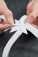 Utilisation de bandes de papier pour créer des décorations en forme d'étoile - répétition de la technique de pliage pour créer plusieurs sections épineuses
