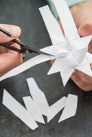 Utiliser des bandes de papier pour créer des décorations en forme d'étoile - couper l'excès de papier loin des coins triangulaires