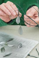 Utilisation de coton et de fil de jardin pour créer un arbre de Noël - Feuilles de cotoneaster suspendues sur les branches