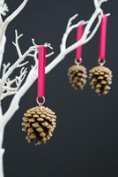 Faire des décorations de Noël avec des pommes de pin et du ruban - décorations finies