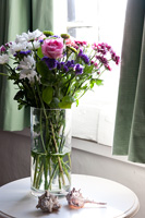 Roses et chrysanthèmes dans un vase en verre