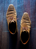 Chaussures en daim sur plancher en bois foncé