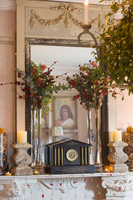Cheminée ornée avec miroir français, chandeliers en pierre et décorations florales de Noël