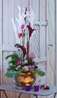 Arrangement de fleurs de Noël avec feuillage de conifères, roses, lys Calla et pommes de pin