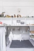 Chambre d'enfant blanche avec rangement au dessus du lit