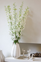 Fleurs de Larkspur blanc dans un vase de cheminée en calcaire